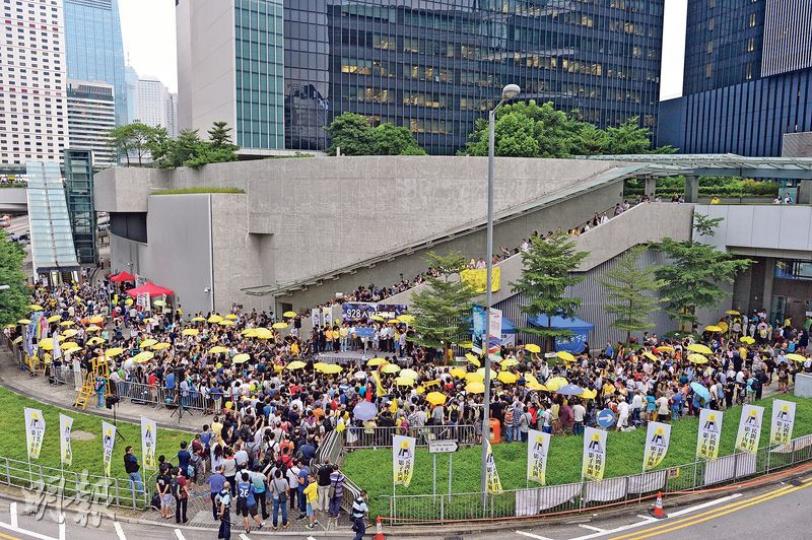 雨傘運動兩周年紀念集會在當年金鐘「佔領區」核心地帶「連儂牆」對開舉行，主辦方和警方都指約有1000人出席。參加者於下午5時58分、即兩年前警方發射首枚催淚彈的時候，全場默站3分鐘，不少人再次舉起黃傘。（鄧宗弘攝）佔中三子戴耀廷（左）、陳健民（右）、朱耀明（不在相中），以及香港天主教區榮休主教陳日君樞機（中）昨均有出席集會。（李紹昌攝）全場默站時，有參加者流淚。（李紹昌攝）