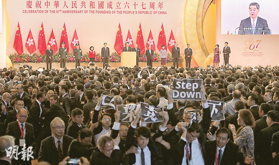 獲邀出席國慶酒會的多名民主黨立法會議員，包括涂謹申、鄺俊宇、林卓廷等昨日在特首梁振英上台致辭時，突高舉「梁振英下台」標語抗議，被多名保安攔截及帶離場。（李紹昌攝）民主黨多名立法會議員及區議員在酒會上抗議，高叫「梁振英下台」，該黨中西區區議員吳兆康躺在地上被保安拖走。（李紹昌攝）