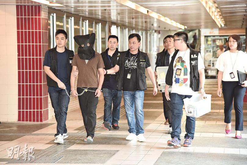 涉及8日內4宗便利店持刀劫案被捕的疑犯（左二），昨午由探員黑布蒙頭押到其曾經犯案的沙田新田圍邨商場4樓平台7-Eleven便利店作案情重組。（鍾炳然攝）