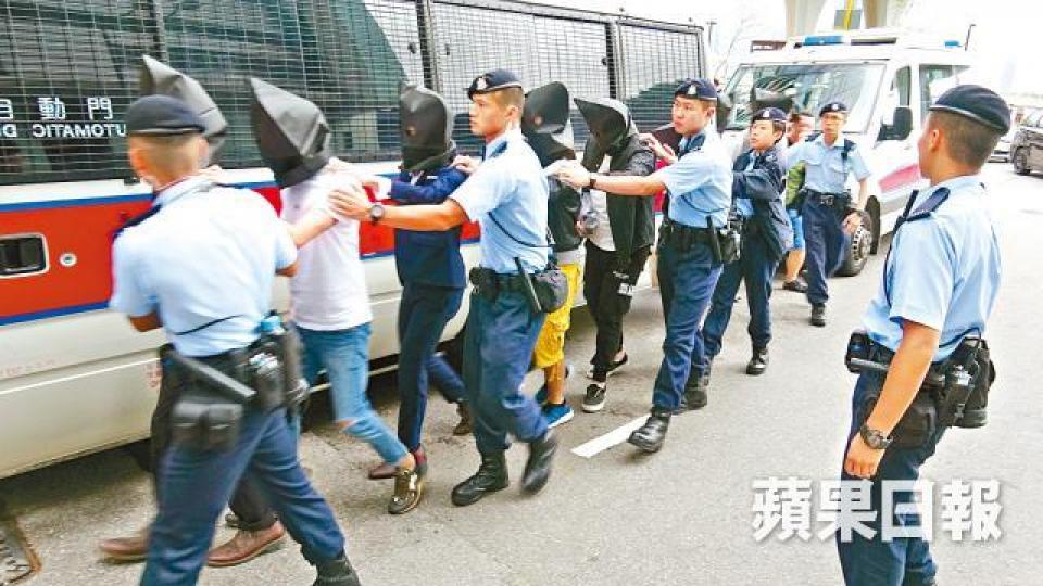 ■警方昨再搗破倫敦金集團,將騙徒蒙頭押返警署調查。姜偉康攝 ■警方昨再搗破倫敦金集團,將騙徒蒙頭押返警署調查。姜偉康攝