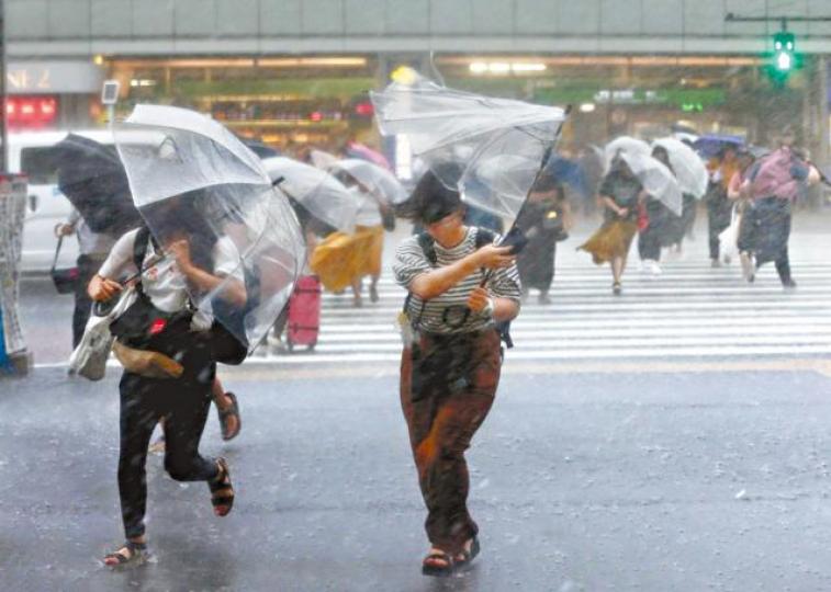 ■颱風中橫風橫雨把行人雨傘也吹歪。互聯網 ■颱風中橫風橫雨把行人雨傘也吹歪。互聯網