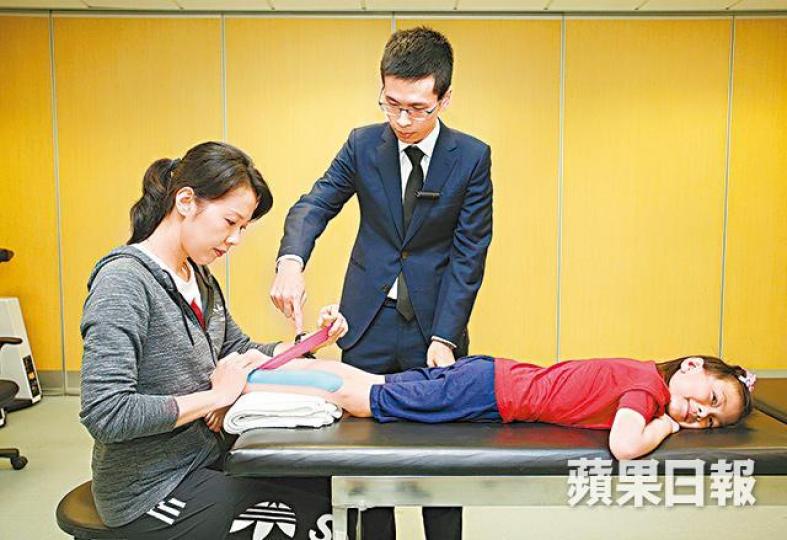 ■註冊物理治療師任子霆(中)表示,活動布貼能抑制小腿肌肉,令小童更易做到腳踭落地,改善腳尖行路情況。李潤芳攝 ■註冊物理治療師任子霆(中)表示,活動布貼能抑制小腿肌肉,令小童更易做到腳踭落地,改善腳尖行路情況。李潤芳攝