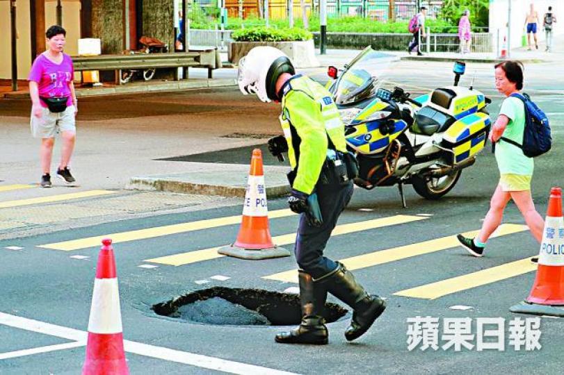 ■山道近干諾道西昨早出現路陷,警員封閉行車線。李家傑攝 ■山道近干諾道西昨早出現路陷,警員封閉行車線。李家傑攝