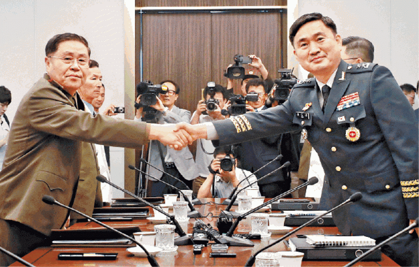 ■北韓代表安益山（左）跟南韓代表金度均（右）會談前先握手。路透社■安益山步行越過板門店兩韓分界線，進入南韓國境。美聯社