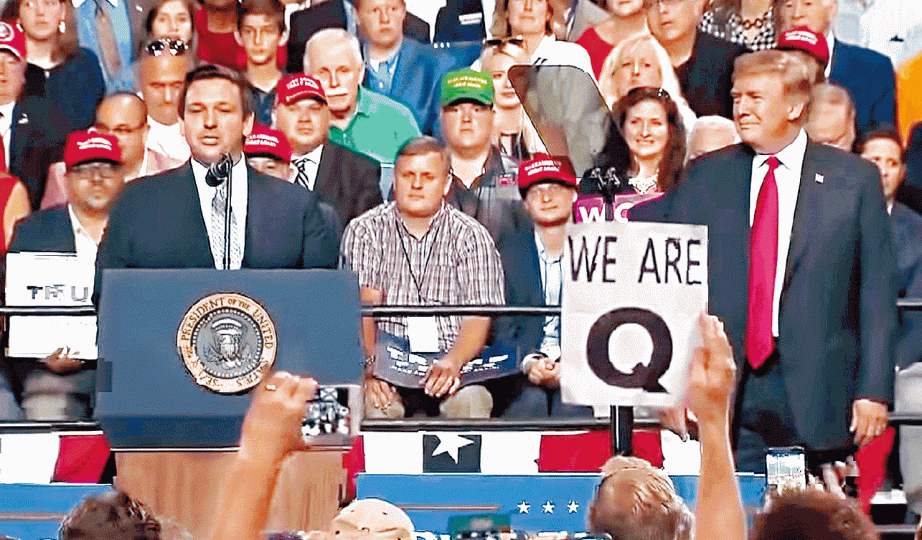 ■特朗普(右)周二晚佛州出席集會中,「Q」的追隨者高舉「我們是Q」標語,令該陰謀論社群打入主流視線。■「QAnon」成員身穿「Q」字T恤。■「WWG1WGA」(箭嘴示)是「Q」格言「Where we go one, we go all」。 ■特朗普(右)周二晚佛州出席集會中,「Q」的追隨者高舉「我們是Q」標語,令該陰謀論社群打入主流視線。■「QAnon」成員身穿「Q」字T恤。■「WWG1WGA」(箭嘴示)是「Q」格言「Where we go one, we go all」。