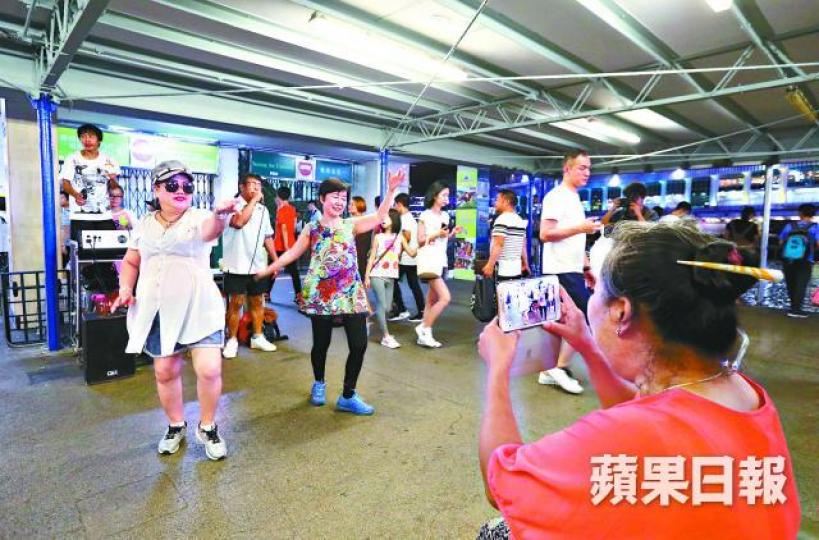 ■菜街大媽移師尖沙嘴天星碼頭載歌載舞。李家皓攝■「旺角阿Lam」被康文署職員阻撓後,轉用木結他演奏。 ■菜街大媽移師尖沙嘴天星碼頭載歌載舞。李家皓攝■「旺角阿Lam」被康文署職員阻撓後,轉用木結他演奏。