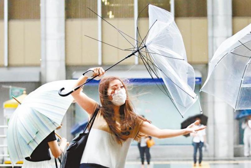 ■颱風「珊珊」昨逼近日本本州,吹得東京市民人仰傘翻。路透社 ■颱風「珊珊」昨逼近日本本州,吹得東京市民人仰傘翻。路透社