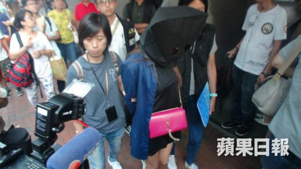 其中一名串謀詐騙涉女子被蒙頭帶署。 其中一名串謀詐騙涉女子被蒙頭帶署。