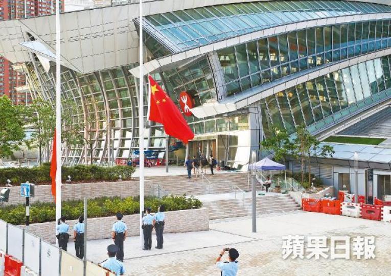 高鐵西九龍站外昨傍晚有警員舉行降旗儀式。馬泉崇攝運房局長陳帆（右）與廣東省人民政府副秘書長林積（左）在啟用儀式合照。