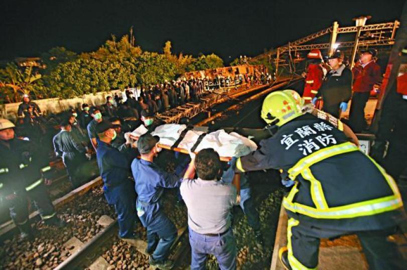救援人員將死者遺體運出車廂。 救援人員將死者遺體運出車廂。