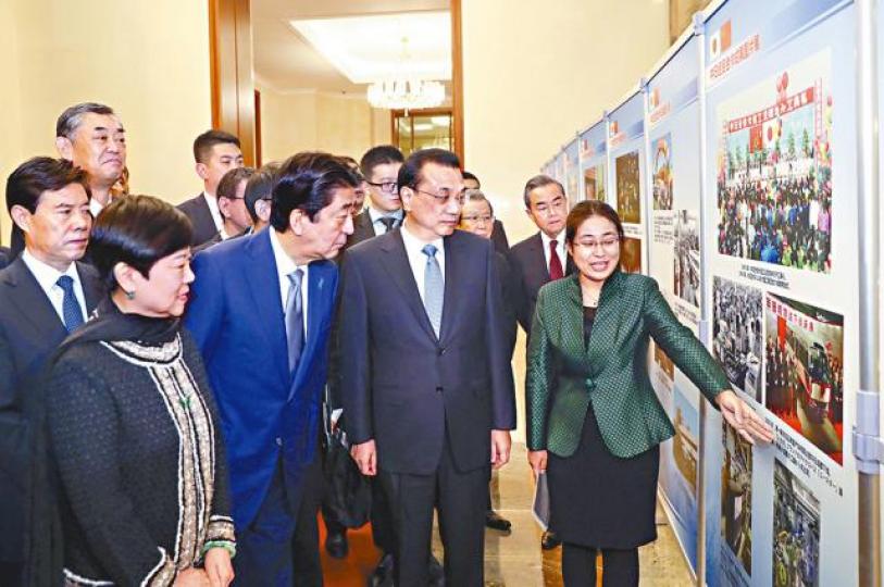 李克強與安倍參觀中日經貿合作成果圖片展。中新社 李克強與安倍參觀中日經貿合作成果圖片展。中新社