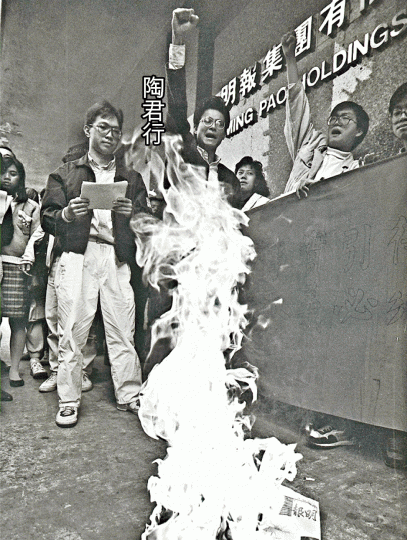 1988年，陶君行與大專學生不滿查良鏞以《明報》推銷雙查方案，到報社外燒報紙抗議。黑白資料圖片