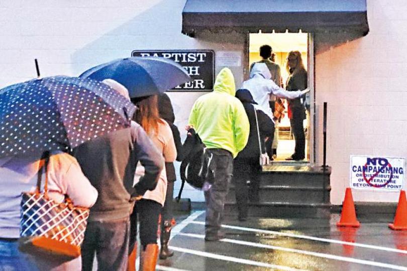 賓夕凡尼亞州巴特勒的選民昨日冒雨投票。美聯社 賓夕凡尼亞州巴特勒的選民昨日冒雨投票。美聯社