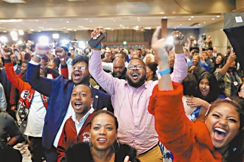 得悉民主黨候選人與對手差距收窄的消息時,支持者歡喜若狂。路透社 得悉民主黨候選人與對手差距收窄的消息時,支持者歡喜若狂。路透社