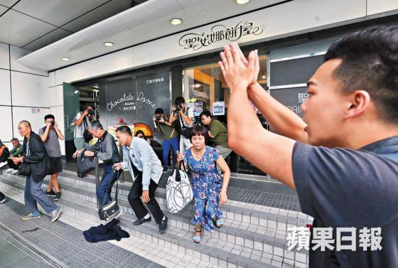 召集人王進洋(右)勸內地旅客不要坐在商店梯級。陳善南攝 召集人王進洋(右)勸內地旅客不要坐在商店梯級。陳善南攝