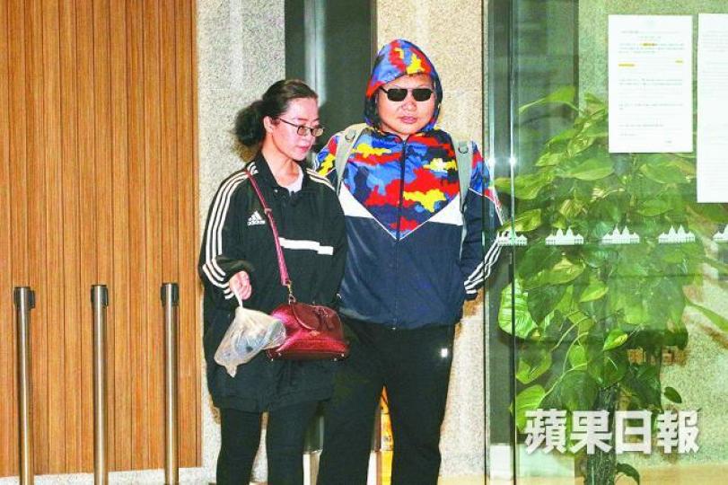 被告李旭珩（右）承認刑毀等罪被判緩刑，在妻子陪同下離開西九龍法院。李潤芳攝纏住犯人在床上的鐵鏈遭疑犯勒斷。