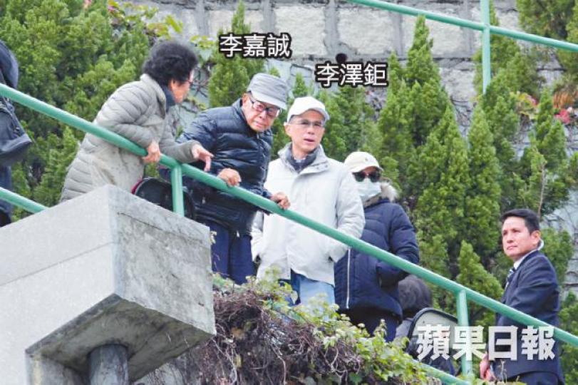李嘉誠每年元旦都帶同家人拜祭亡妻莊月明。保鑣為王儷橋、李澤鉅（右一）同囡囡開路。李嘉誠扶住欄杆慢慢落樓梯，兩個仔緊隨，身邊仲有幾個保鑣傍實。有個男人突然走上前話有大project同李嘉誠傾。