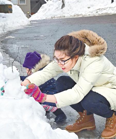 鍾嘉欣和大女夾手夾腳砌雪人。互聯網圖片