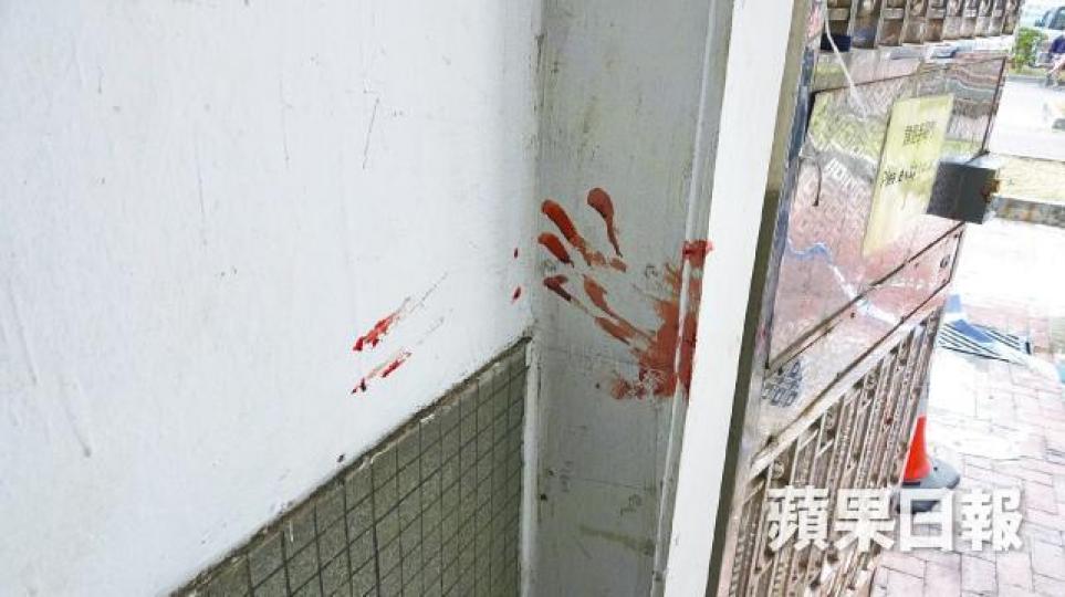 捱斬男女送院救治,涉事大廈牆身留下血掌印。張家豪攝 捱斬男女送院救治,涉事大廈牆身留下血掌印。張家豪攝