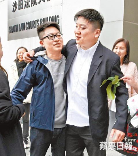 身穿西裝的首被告陳穗豪與次被告陳宗達昨離庭時相擁,有親友持碌柚葉替他們「洗衰運」。李潤芳攝 身穿西裝的首被告陳穗豪與次被告陳宗達昨離庭時相擁,有親友持碌柚葉替他們「洗衰運」。李潤芳攝
