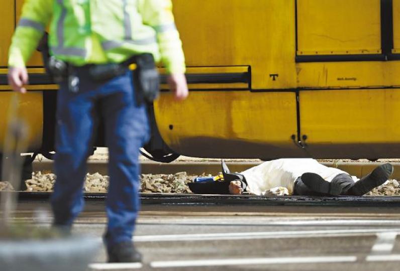 槍擊案一名死者遺體在現場用白布覆蓋。荷蘭警方發放涉案男子塔尼什施襲前在電車的閉路電視畫面。事後大批荷槍實彈警員到場戒備。 槍擊案一名死者遺體在現場用白布覆蓋。荷蘭警方發放涉案男子塔尼什施襲前在電車的閉路電視畫面。事後大批荷槍實彈警員到場戒備。
