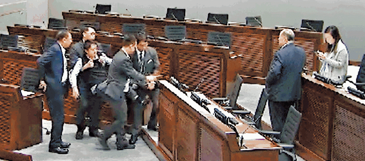 許智峯昨被四名保安員抬出會議廳。立法會直播畫面截圖 許智峯昨被四名保安員抬出會議廳。立法會直播畫面截圖