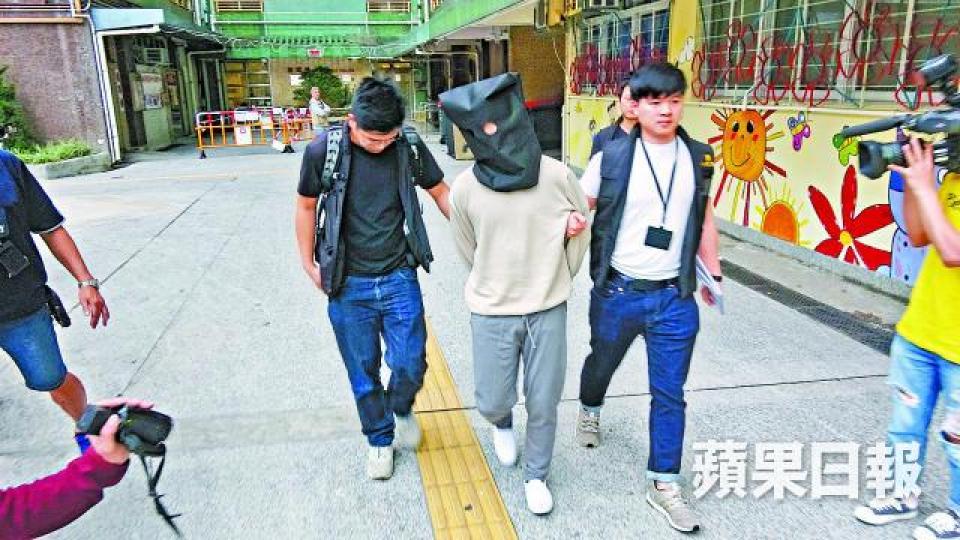 其中一名疑犯被警員押回柴灣住所調查。 其中一名疑犯被警員押回柴灣住所調查。