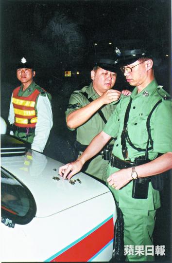 九七回歸後一名警員換上新警章。 九七回歸後一名警員換上新警章。
