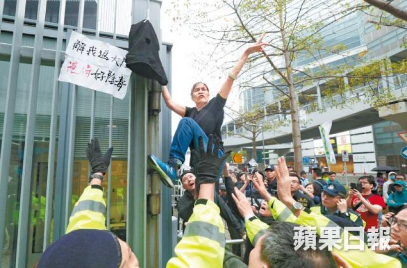 「女長毛」爬上政府總部大閘逃避保安員及警方追逐。張志華攝