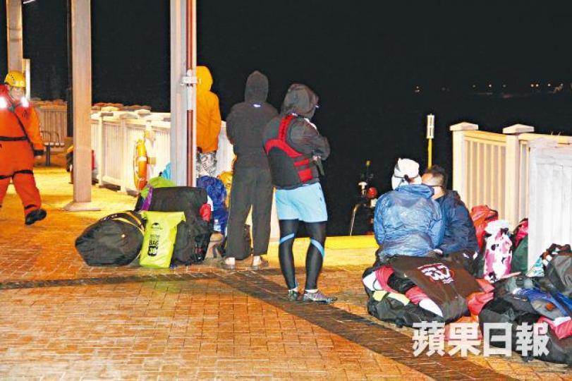 一男子墮海失蹤，其他同行人士在大澳碼頭等消息。警方及消防出動船隻到場搜救。　黎家駒攝