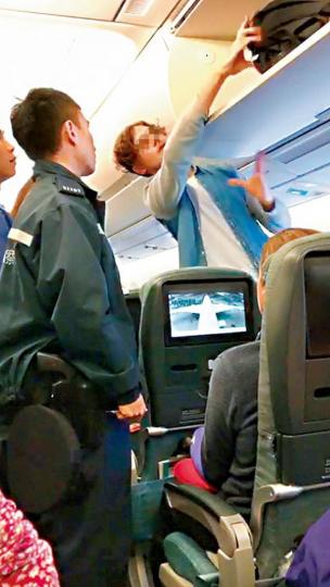 警員在客機上向被指「鹹豬手」的外籍男子查問。讀者提供圖片 警員在客機上向被指「鹹豬手」的外籍男子查問。讀者提供圖片