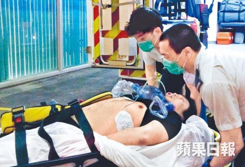 救護員將社工送院搶救。溫瑞麟攝 救護員將社工送院搶救。溫瑞麟攝