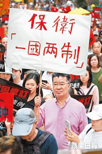 劉夢熊舉起保衞一國兩制橫額參與遊行。黎樹雄攝 劉夢熊舉起保衞一國兩制橫額參與遊行。黎樹雄攝