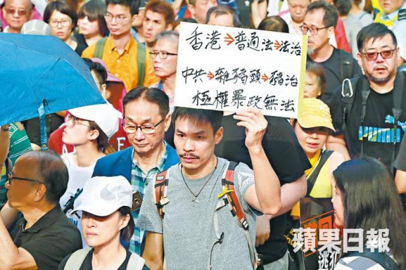 有遊行人士高舉寫有「極權暴政無法」等字眼的橫額。 有遊行人士高舉寫有「極權暴政無法」等字眼的橫額。