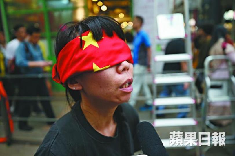 藝術家魂游用印有黃星的紅布蒙着眼睛,跟着遊行的隊尾摸着黑走。何敏文 藝術家魂游用印有黃星的紅布蒙着眼睛,跟着遊行的隊尾摸着黑走。何敏文