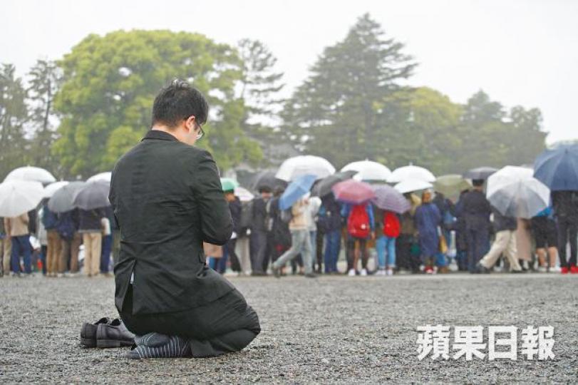平成時代終結,民眾在皇居外向天皇表達敬意,有人跪地禱告。周智堅攝 平成時代終結,民眾在皇居外向天皇表達敬意,有人跪地禱告。周智堅攝
