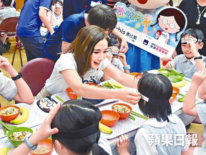 李施嬅昨出席護眼活動，為小孩戴眼罩蒙眼食午餐。