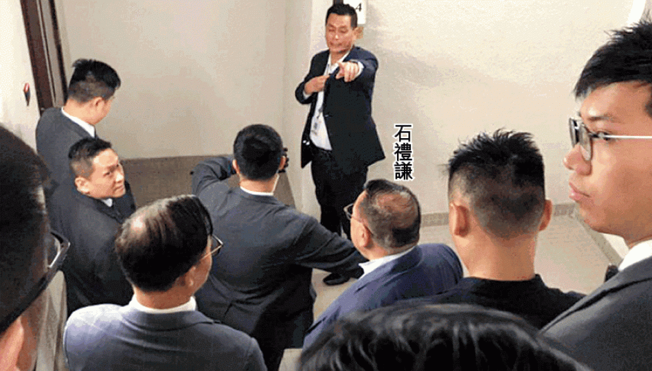 石禮謙昨在保安護送下經後樓梯到會議室,記者被阻止追訪。有記者被立法會保安抓傷手臂。 石禮謙昨在保安護送下經後樓梯到會議室,記者被阻止追訪。有記者被立法會保安抓傷手臂。