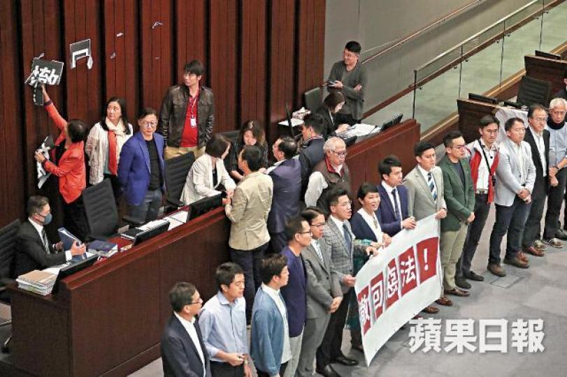泛民議員昨在主席台前拉起橫額要求撤回修例,其間民建聯蔣麗芸撕走貼在牆上的標語。何家達攝 泛民議員昨在主席台前拉起橫額要求撤回修例,其間民建聯蔣麗芸撕走貼在牆上的標語。何家達攝