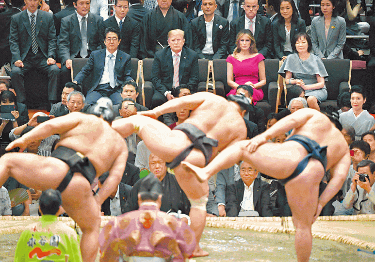 特朗普伉儷在安倍夫婦陪伴下觀看相撲力士賽前進場儀式。在特朗普(紅圈示)進場時觀眾站立歡呼,但也夾雜噓聲。美聯社相撲賽場館外有特朗普支持者歡迎他。 特朗普伉儷在安倍夫婦陪伴下觀看相撲力士賽前進場儀式。在特朗普(紅圈示)進場時觀眾站立歡呼,但也夾雜噓聲。美聯社相撲賽場館外有特朗普支持者歡迎他。