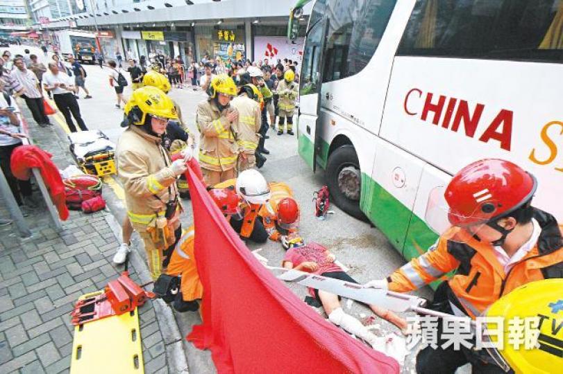 荃灣有直通巴撞倒一名過路八旬婦，救援人員到場將她救出，送院搶救。劉柏麟攝
