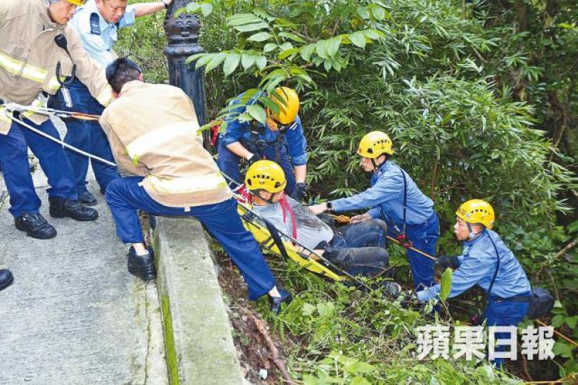 消防員用山兜救起墮坡工人。
消防員用山兜救起墮坡工人。