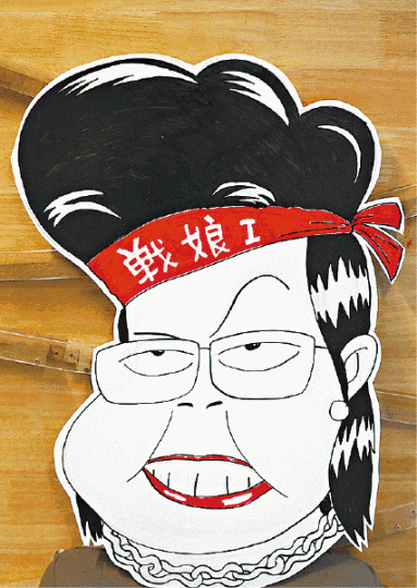 「戰娘」林鄭頭繫紅頭巾,露出猙獰表情。 「戰娘」林鄭頭繫紅頭巾,露出猙獰表情。